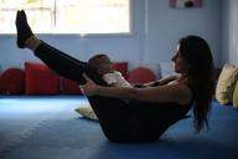 Woman practicing Yoga with her baby | IANS