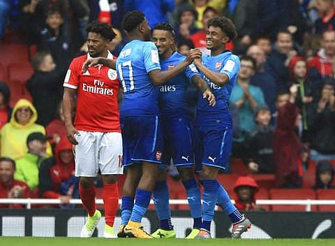 Arsenal's Theo Walcott, centre, celebrates scoring his side's third goal of the game with teammates during the Emirates Cup soccer match against Benfica, at the Emirates Stadium in London. | AP