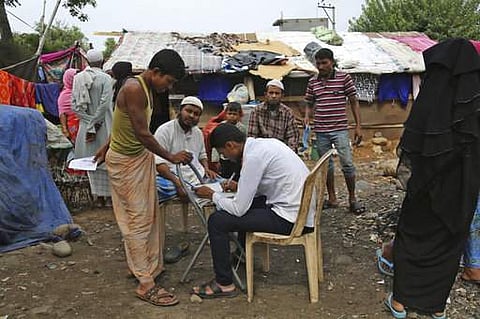 A United Nations High Commissioner for Refugees (UNHCR) employee updates the records for Rohingya refugees living in a temporary shelter on the outskirts of Jammu, India, Tuesday, June 20, 2017. Facing persecution in Myanmar, thousands of members of Myanm
