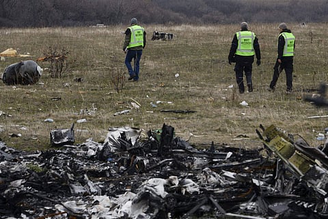 MH17 flight recovery team members examine one of the areas of the Malaysia Airlines Flight 17 plane crash in the village of Hrabove. (File photo | PTI)