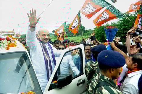 BJP President Amit Shah waves at supporters as they welcome him on his arrival at Basantapur village on the outskrits of Bhubaneswar on Thursday. | PTI