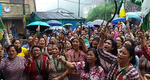 Activists of Gorkha Janmukti Morcha's women wing Nari Morcha wielding sickles wearing traditional Dhaka saree and chaubandi choli during a protest rally at Darjeeling on Thursday. | Express