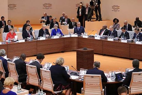 German Chancellor Angela Merkel, left, gives the opening speech during the first working session on the first day of the G-20 summit in Hamburg, northern Germany, Friday, July 7, 2017. Others are, from left, Chinese President Xi Jinping, U.S. President Do
