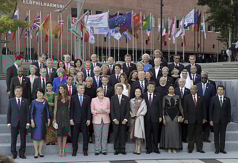 The G-20 participants and their spouses pose for a family photo in front of the Elbphilharmonie concert hall on the first day of the G-20 summit in Hamburg northern Germany Friday July 7 2017. (AP)