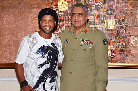 In this photo released by the Inter Services Public Relation Department, the media wing of the Pakistan Armed Forces, Saturday, July 8, 2017, Brazilian soccer star Ronaldinho, left, and Pakistan Army Chief Gen. Qamar Javed Bajwa pose for photograph after