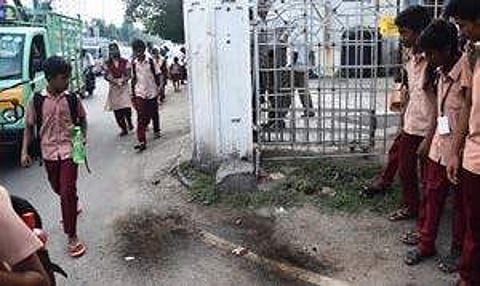 Students observing the spot where Subash (R) fell to his death from the footboard of an MTC bus at Arcot Road, Kodambakkam | Ashwin Prasath