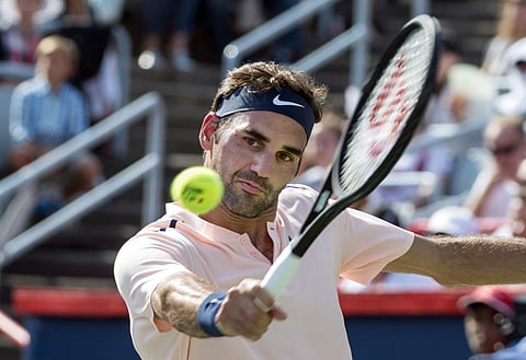 Roger Federer, of Switzerland, returns the ball to Robin Haase, of the Netherlands, during Rogers Cup tennis action in Montreal. | AP