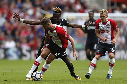 Swansea City's Tammy Abraham, left, and Southampton's Jack Stephens battle for the ball during the English Premier League soccer match at St Mary's Stadium, Southampton. | AP