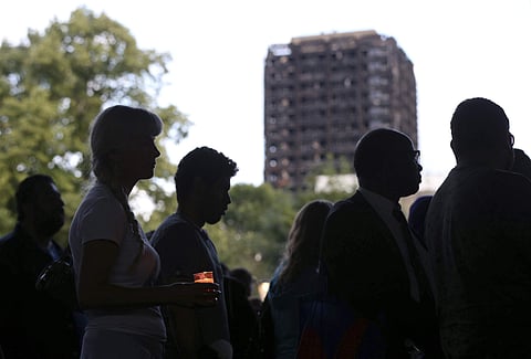 Candles are lit near to the burned out Grenfell Tower apartment building | AP