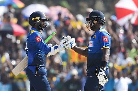 Sri Lankan cricketer Upul Tharanga (L) and captain Angelo Mathews celebrate their victory of the second one-day internationals (ODI) cricket match between Sri Lanka and Zimbabwe at the Galle International Cricket Stadium in Galle on July 2, 2017. | AFP