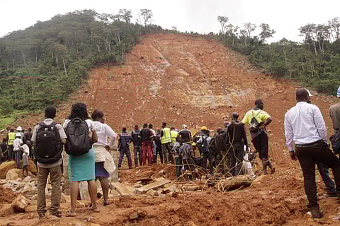 Red Cross volunteers digging for survivors at the scene of heavy flooding and mudslides is seen in the picture. (Photo | AP)