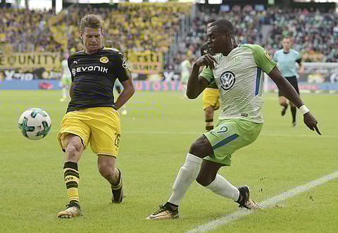 Wolfsburg's Nany Landry Dimata, right, and Dortmund's Lukasz Piszczek vie for the ball during the German Bundesliga soccer match between VfL Wolfsburg and Borussia Dortmund. | AP
