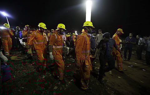 Rescuers carry the body of a victim recovered from upturned coaches of the Kalinga-Utkal Express after an accident near Khatauli, in Uttar Pradesh. (AP)