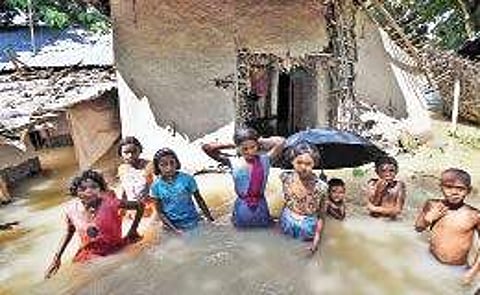 Children stand waist-deep in flood water awaiting the rescue workers in Katihar district of Bihar on Saturday | PTI