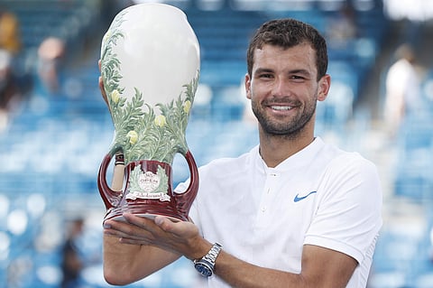 Grigor Dimitrov, of Bulgaria, holds the Rookwood Cup after defeating Nick Kyrgios, of Australia, in the men's singles final at the Western and Southern Open. | AP