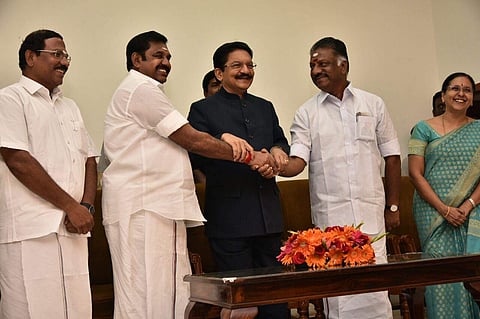 Chief Minister Edapadi Palanisamy shaking hands with O Pannerselvam who was sworn in as finance minister at Raj Bhavan on Monday. (EPS | P Jawahar)
