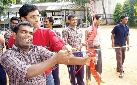 A team member from Solanki’s camp teaching archery to a visually challenged man
