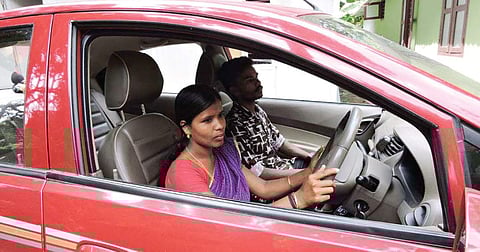 An adivasi woman being given driving lessons in the Model Residential School grounds at Mukkali, Attappadi