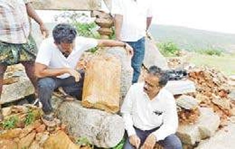 Archaeologist E Siva Nagi Reddy examining the broken pillars found at a Buddhist site on Bhairava Gutta in Guntur district on Sunday | Express