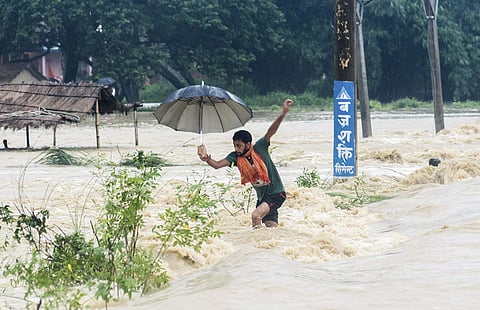 A Nepalese man looses his balance while crossing a flooded street in Birgunj, Nepal. (File photo)
