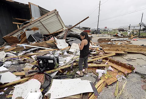 A woman looks over the debris from her family business destroyed by Hurricane Harvey. (Photo | AP)