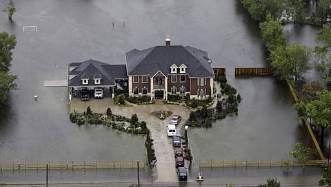 A home is surrounded by floodwaters from Tropical Storm Harvey . (AP)
