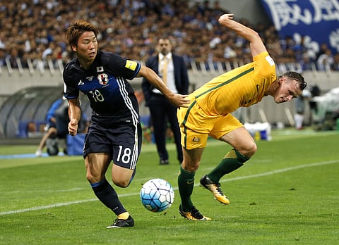 Japan's Takuma Asano (L) takes the ball away from Australia's Brad Smith during their World Cup Group B qualifying fixture. (AP)
