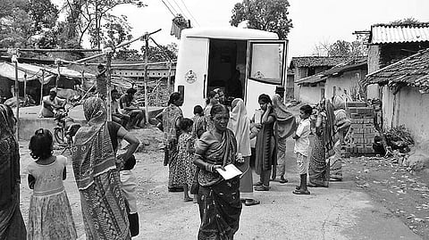 Patients wait for check-up near a mobile medical van in Sundargarh district | Express