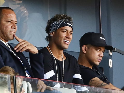 Brazilian soccer star Neymar smiles as he watches the match at the Parc des Princes stadium in Paris, Saturday. | AP