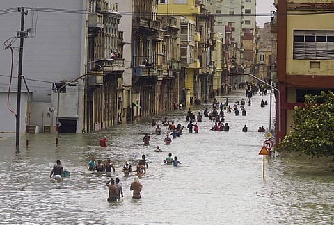 People move through flooded streets in Havana after the passage of Hurricane Irma, in Cuba on Sept. 10, 2017. (Photo | AP)