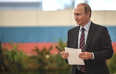 Russian President Vladimir Putin carries his ballot at a polling station during the municipal election in Moscow, Russia. (AP)