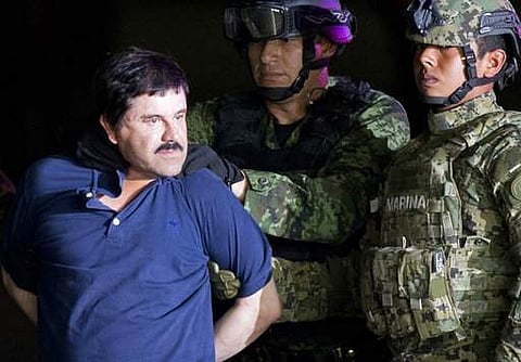 a handcuffed Joaquin 'El Chapo' Guzman is made to face the press as he is escorted to a helicopter by Mexican soldiers and marines at a federal hangar in Mexico City. | AP