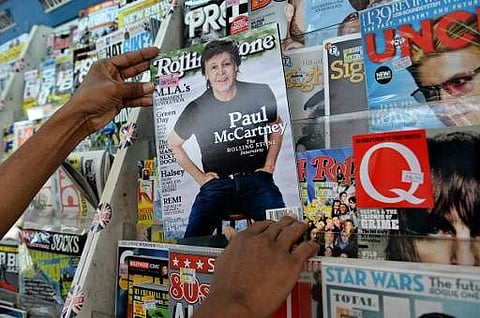 A vendor pulls out Rolling Stone magazine for sale | AFP