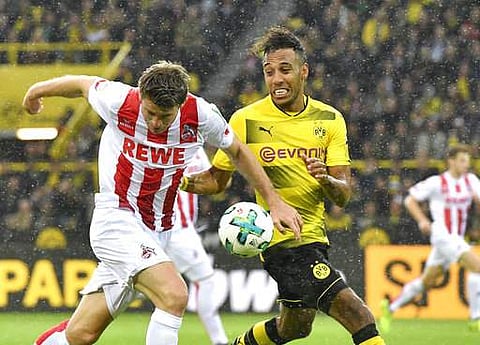 Dortmund's Pierre-Emerick Aubameyang challenge for the ball with Cologne's Heintz during the German Bundesliga match in Dortmund. | AP