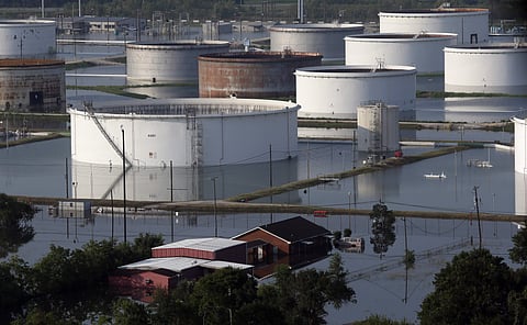 Holding tanks for a chemical company sit next to a home in floodwaters caused Tropical Storm Harvey in Port Arthur, Texas, Friday, Sept. 1, 2017. Port Arthur's major roads were swamped by rising waters brought by Harvey. | AP
