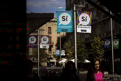 Banners calling to vote Yes in the independence referendum hang on poles as people walk along a street in Sabadell, near Barcelona, Spain on Sept. 7, 2017. (File photo | AP)