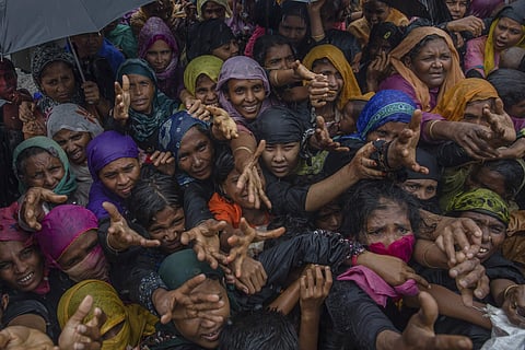 Rohingya Muslim women, who crossed over from Myanmar into Bangladesh, stretch their arms out to collect sanitary products distributed by aid agencies near Balukhali refugee camp, Bangladesh. (File photo | AP)
