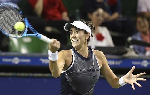 Garbine Muguruza of Spain returns a shot to France's Caroline Garcia (AP)