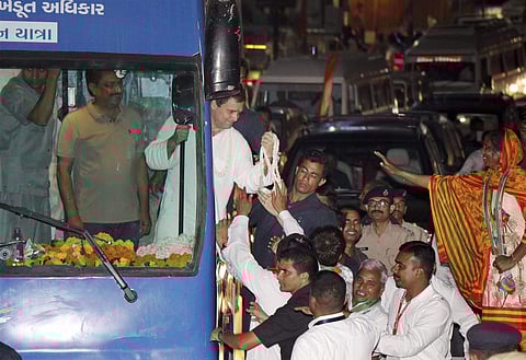 Congress vice president Rahul Gandhi waves to his supporters during his road show at Rajkot on Tuesday. | PTI