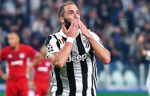 Juventus' Gonzalo Higuain celebrates after scoring during the Champions League group D soccer match between Juventus and Olympiakos. | AP