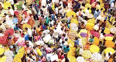 People throng K R Market in Bengaluru on Thursday to buy flowers and other essentials for Ayudh Pooja. Prices of flowers have soared to almost double, with jasmine costing `1,000 a kg just a day before the festival | PUSHKAR V