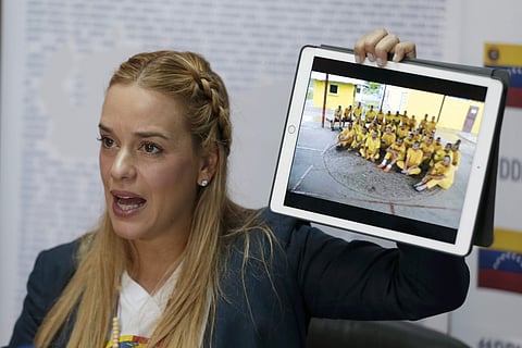 Lilian Tintori, wife of jailed opposition leader Leopoldo Lopez, shows a photo of jailed anti-government protesters, during a meeting with foreign journalists in Caracas, Venezuela. | AP