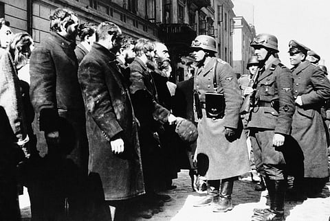 This 1943 file photo shows Nazi officers talking with citizens of the Warsaw ghetto in Poland. (File | AP)