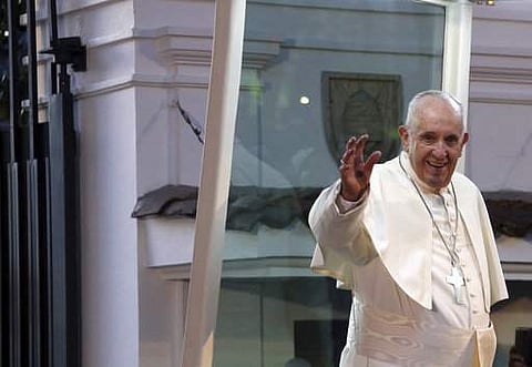 Pope Francis waves to the crowd as he arrives to the Nunciature in Bogota, Colombia. | AP