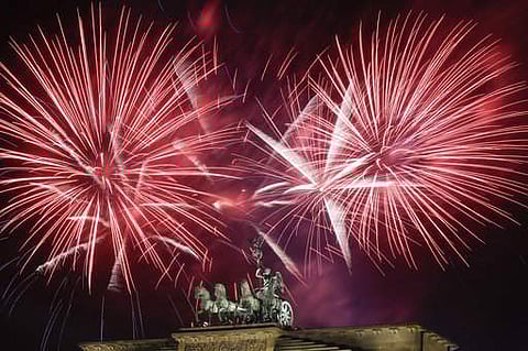 Fireworks light the sky above the Quadriga at the Brandenburg Gate during New Year's celebrations shortly after midnight in Berlin. | AP