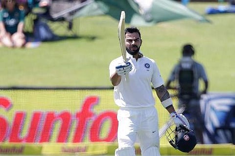 India captain Virat Kohli raises his bat and helmet as he celebrates scoring a century | AFP
