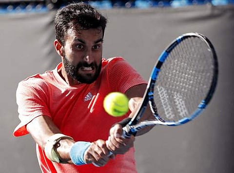 India's Yuki Bhambri makes a backhand return to Marcos Baghdatis of Cyprus during their first round match at the Australian Open tennis championships in Melbourne | Photo: AP