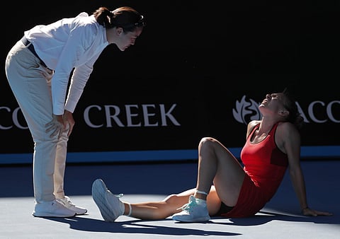 Umpire Julie Minori Kjendlie checks on Romania's Simona Halep after Halep injured her ankle | AP