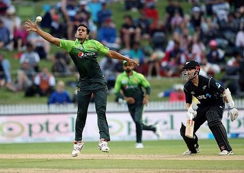 Pakistan's Hasan Ali (L) looks to field off his own bowling during the fourth ODI against New Zealand | AFP