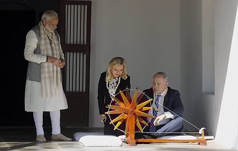 Netanyahu and his wife tried their hands at Gandhi's cherished spinning wheel. (Photo | PTI)